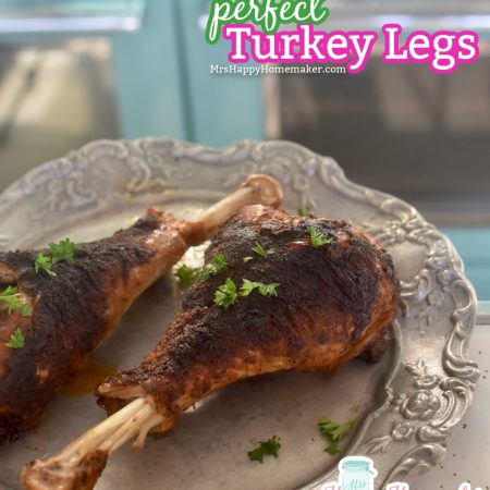 Two roasted turkey legs on a silver plate with floral trim