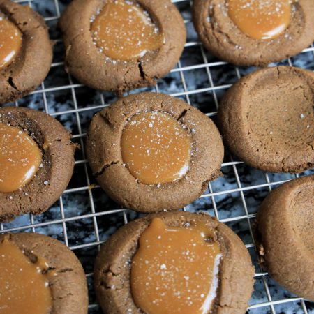 Salted caramel thumbprint cookies on a wire rack