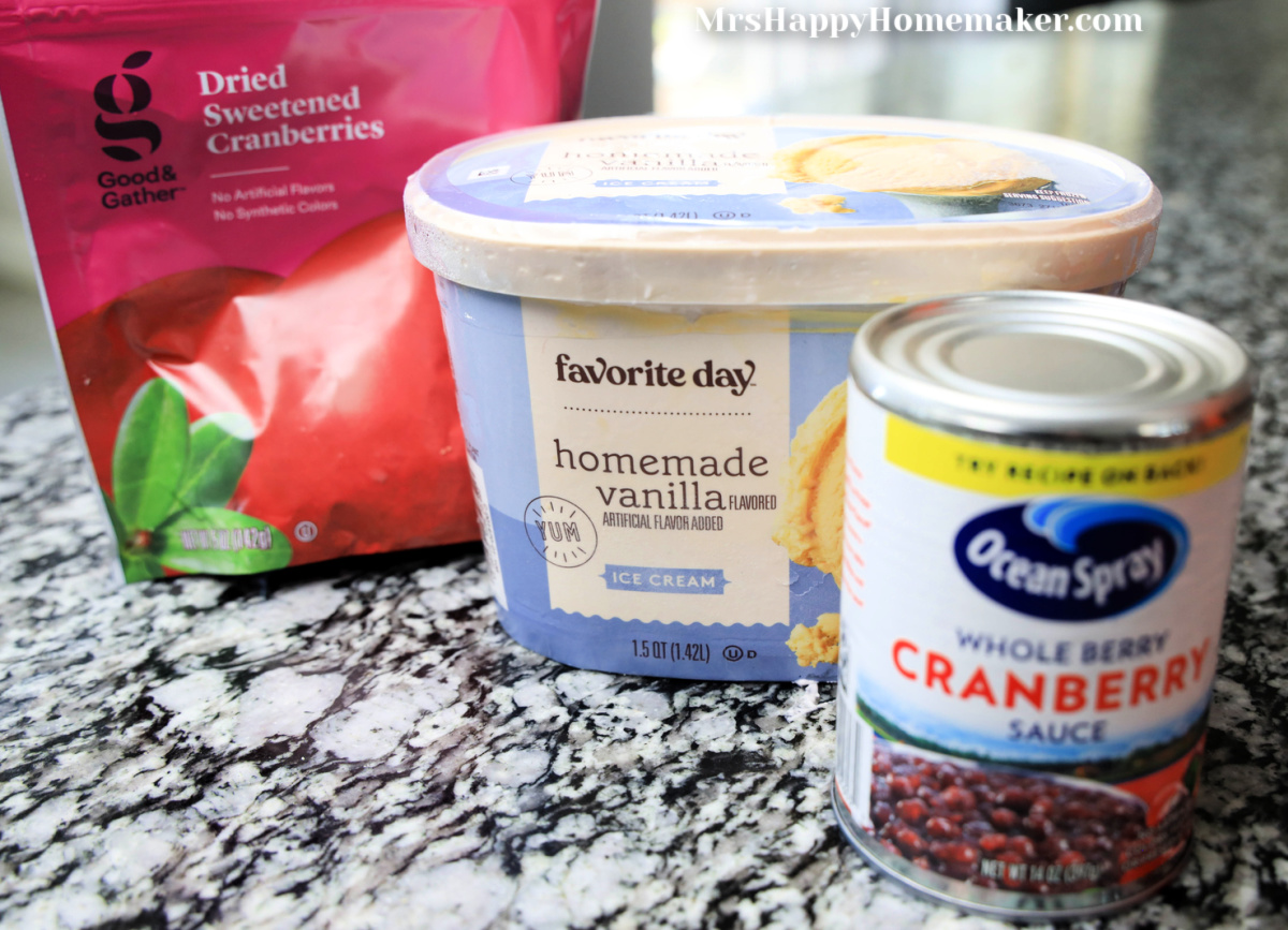A package of dried cranberries, a carton of vanilla ice cream, & a can of cranberry sauce - all on a granite countertop 