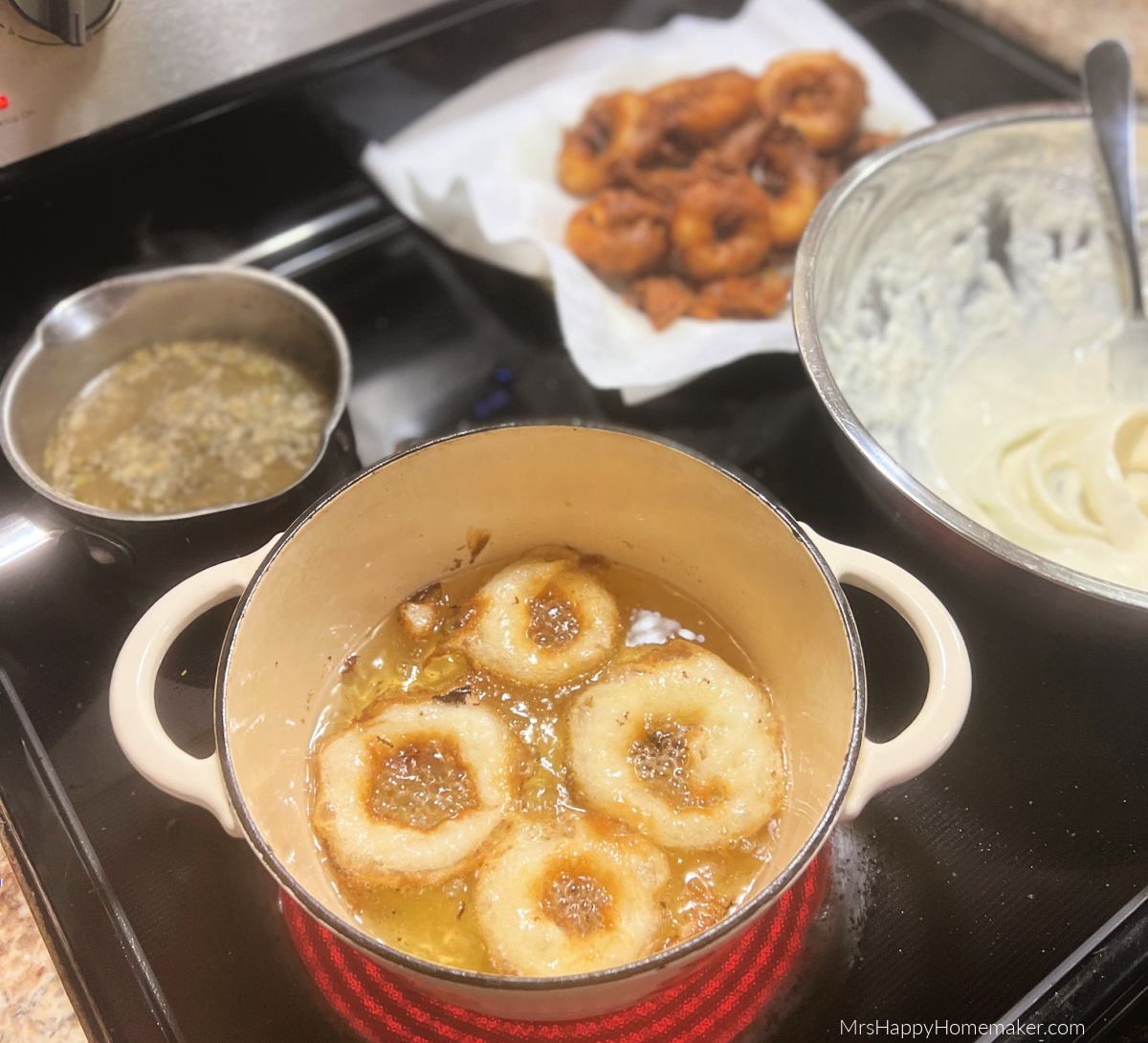 Onion rings frying in a Dutch oven in hot oil on the stovetop