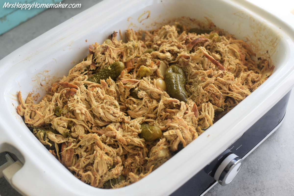 Dill pickle chicken in a white and blue crockpot
