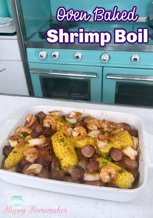 Sheet Pan shrimp boil in a white casserole dish with a vintage blue stove behind it