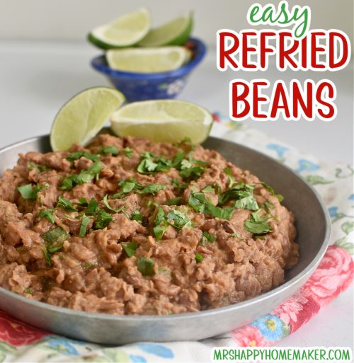 Easy homemade refried beans in a round silver dish on a floral tea towel