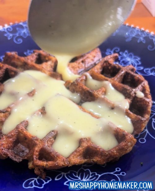 Leftover Stuffing Waffle on a blue plate with gravy being poured on top