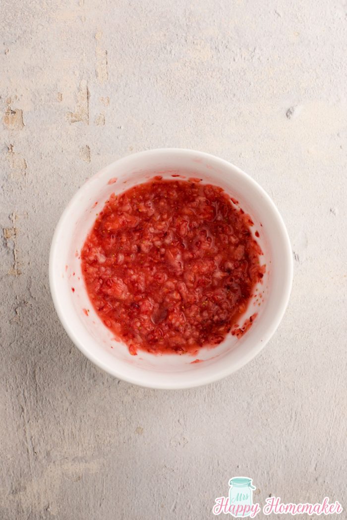 crushed strawberries in a white bowl 