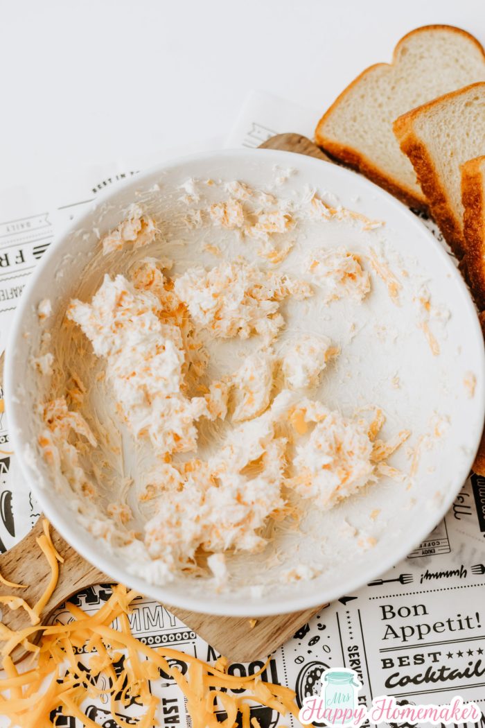 cream cheese and shredded cheese mixed together in a white bowl