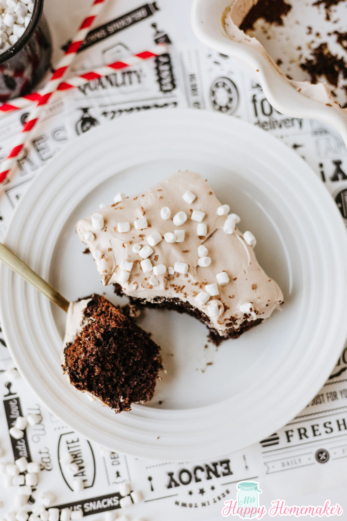 a slice of hot cocoa poke cake with a fork holding a bite of it - all on a white plate