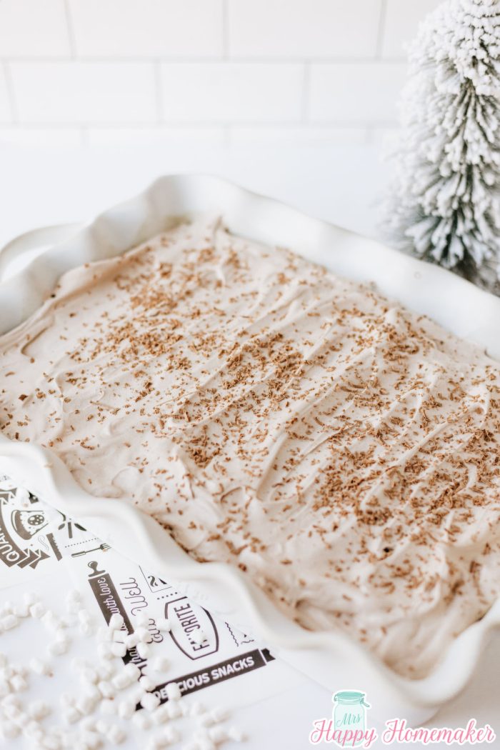 frosted hot cocoa poke cake in a white rectangle cake dish