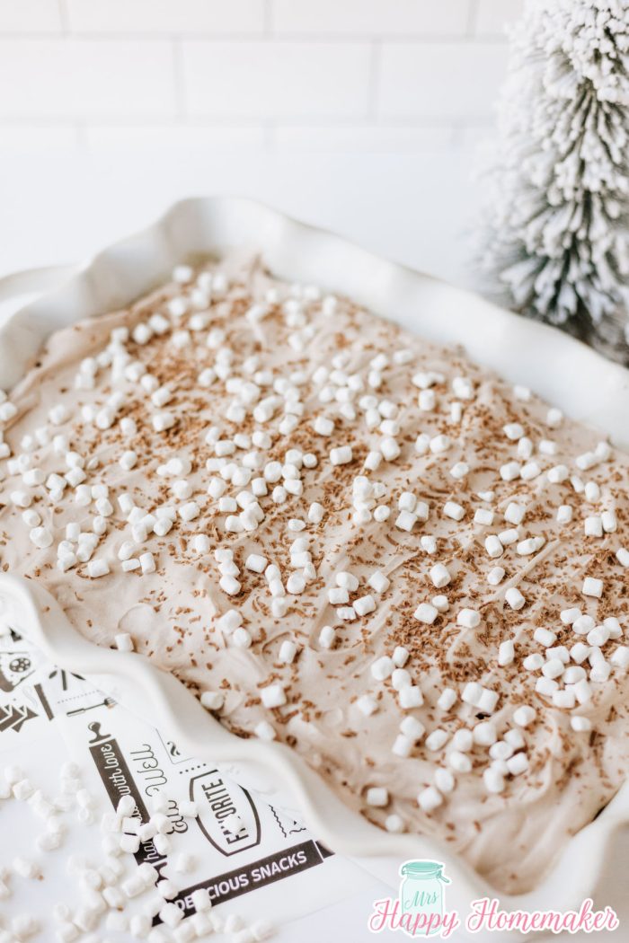 frosted hot cocoa poke cake in a white rectangle cake dish