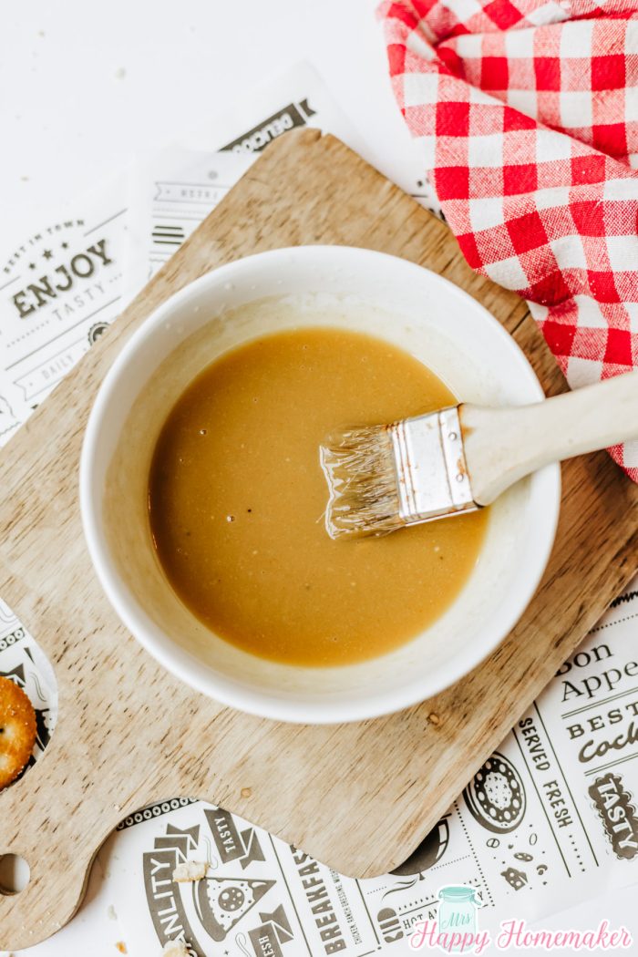 Ritz Cracker Party Sandwiches butter sauce in a white bowl with a pastry brush