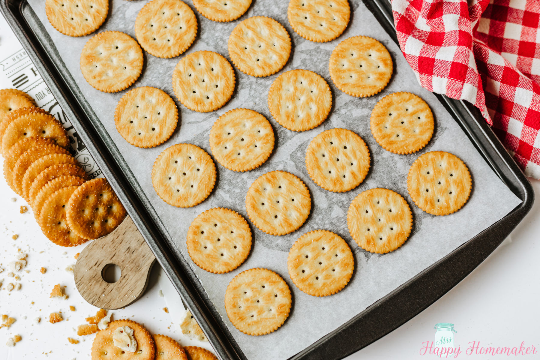 ritz crackers laid out on a parchment paper lined baking sheet
