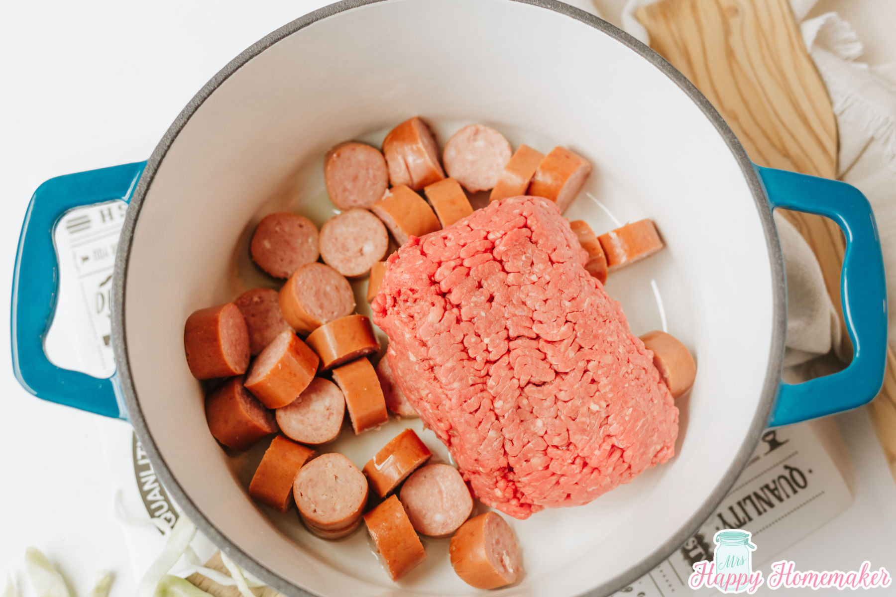smoked sausage and ground beef cooking in a dutch oven