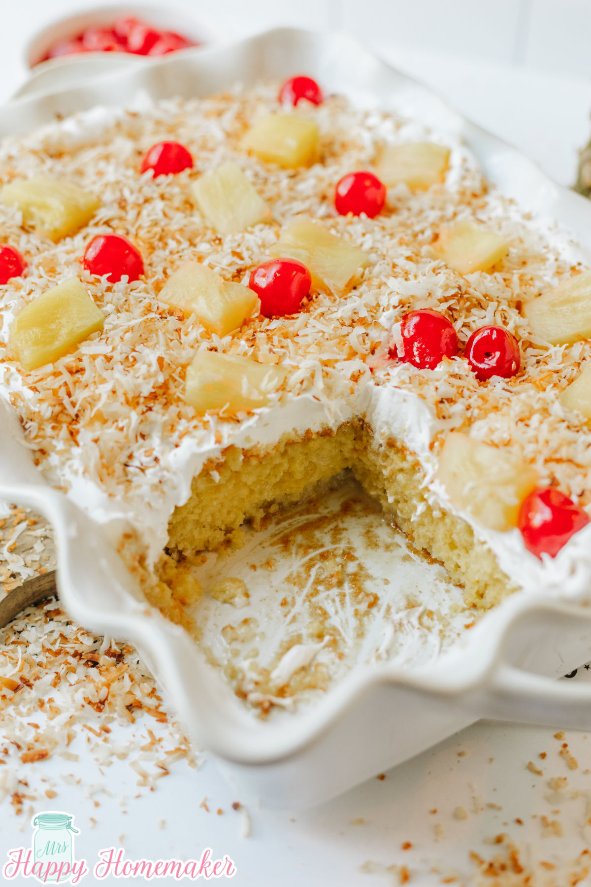 Simple & Easy Pina Colada Poke Cake with a slice cut out of it