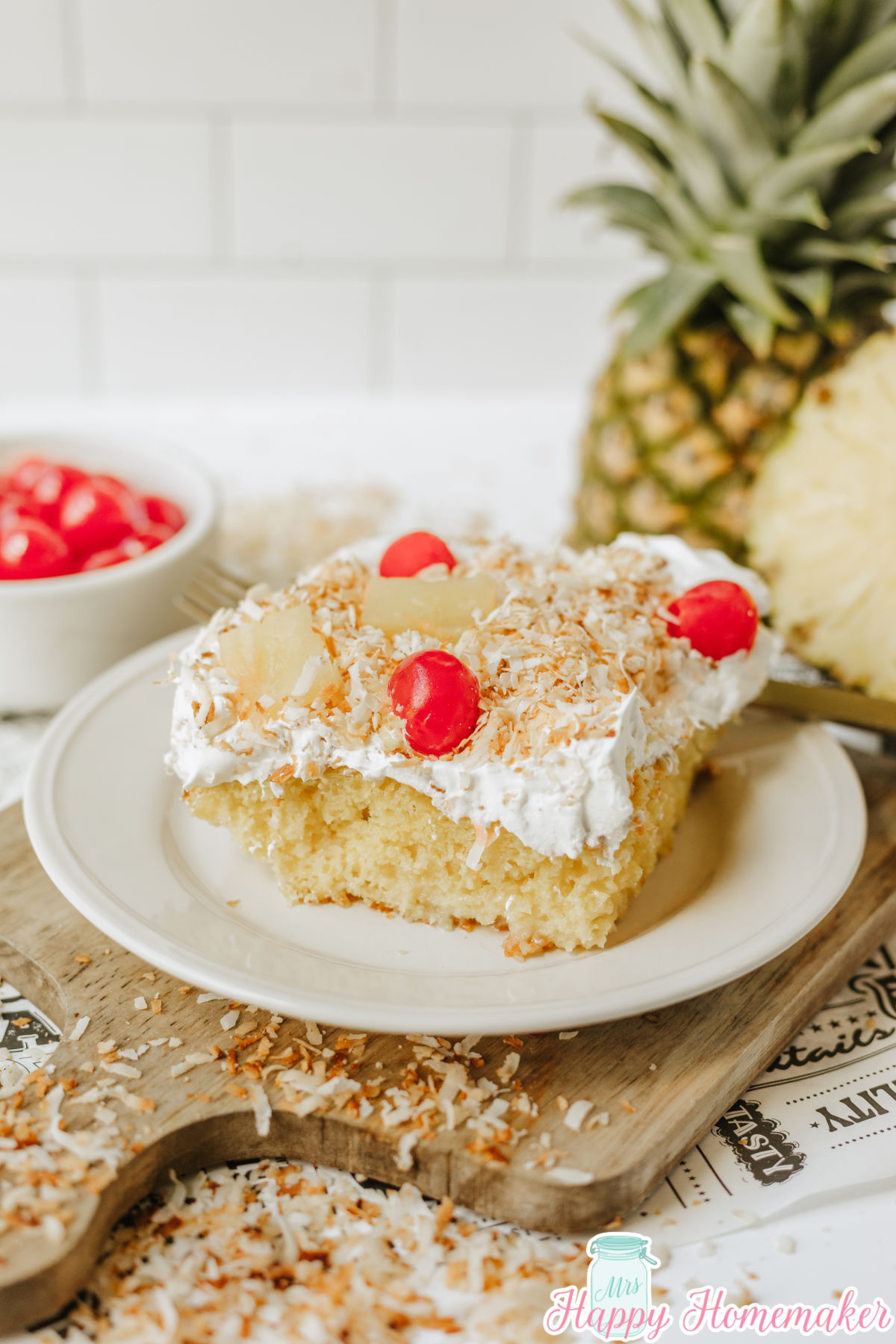 Simple & Easy Pina Colada Poke Cake slice on a white round plate