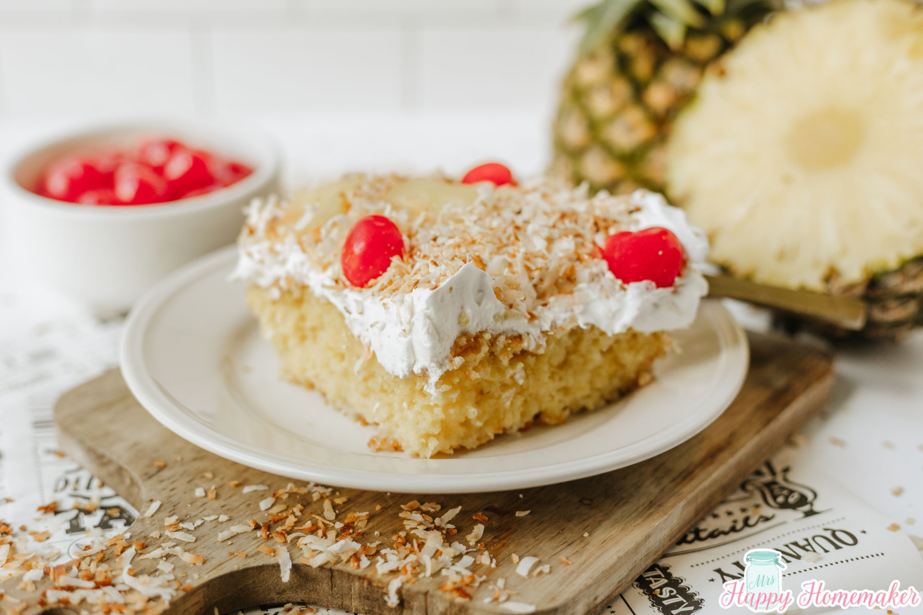 Simple & Easy Pina Colada Poke Cake sliced on a white plate
