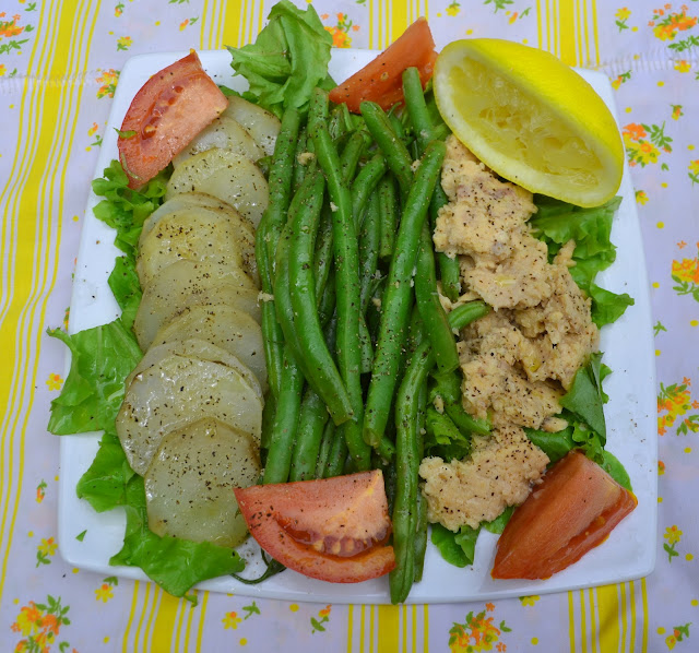 Salmon, Potato, and Green Bean Salad on a plate with a yellow floral tablecloth