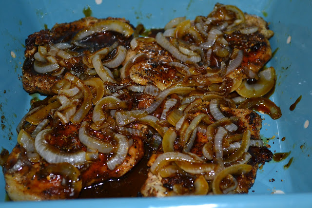 onions layered over pork chops in a casserole dish 
