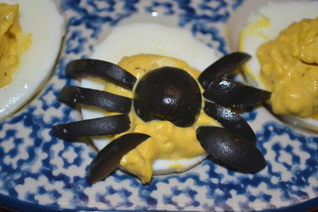 sliced black olives on a deviled egg forming a spider shape