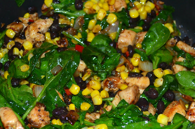 chicken, corn, beans and spinach cooking in a skillet 