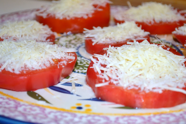 shredded parmesan cheese on sliced tomatoes