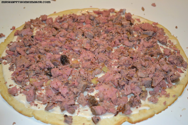 Philly cheesesteak pizza being prepared 
