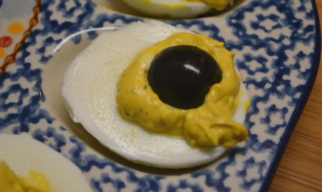 deviled egg with a half of a black olive for the spider's body 