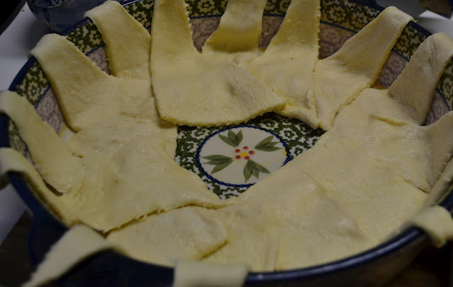 Crescent rolls arranged in a wreath like pattern in a round casserole dish for the crescent ring recipe