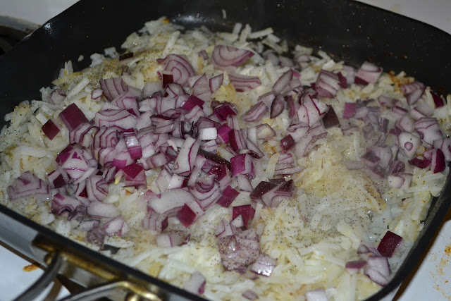 cooking hash browns and onions in a skillet 
